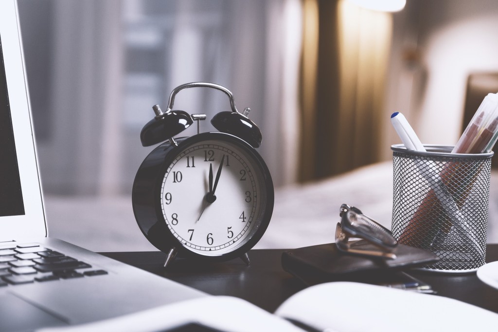 Desk with a clock representing office hours and scheduling.